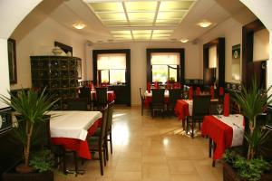 een restaurant met tafels en stoelen met rode en witte tafelkleden bij Gostilna Žolnir in Kostanjevica na Krki