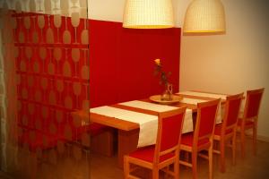een eetkamer met een houten tafel en een rode muur bij Gostilna Žolnir in Kostanjevica na Krki