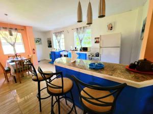 eine Küche mit einer blauen Theke und einigen Stühlen in der Unterkunft Comfort Suites - Two Bedroom Apartment in Choiseul