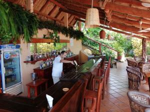 a man standing at a bar in a restaurant at Hotel Catalina Beach Resort in Zihuatanejo +38 photos
