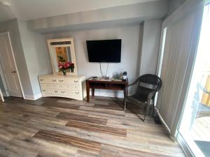 - un salon avec une télévision, une chaise et une table dans l'établissement 2 bedroom with 2 ensuites Unit in Richmond Hill, à Colline De Richmond