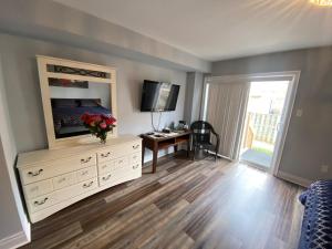 uma sala de estar com uma cómoda branca e uma televisão em 2 bedroom with 2 ensuites Unit in Richmond Hill em Richmond Hill