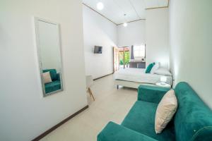 a living room with a green couch and a bed at Natüra Hotel Monteverde in Monteverde Costa Rica
