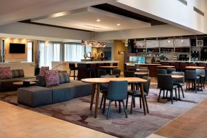 a hotel lobby with tables and chairs and a bar at Courtyard by Marriott Chicago Naperville in Naperville