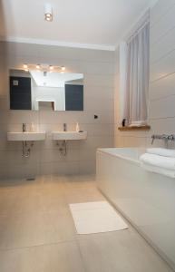 a bathroom with two sinks and a tub and a mirror at Apartment Toni Delux in Split