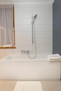 a white bath tub with a shower in a bathroom at Apartment Toni Delux in Split
