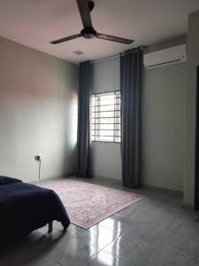 a bedroom with a bed and a ceiling fan at Rumah Putih Homestay, [Mentakab near Temerloh] in Mentekab