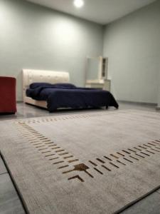 a bedroom with a bed and a rug on the floor at Rumah Putih Homestay, [Mentakab near Temerloh] in Mentekab