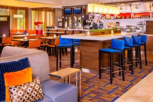 a restaurant with a bar with blue stools at Courtyard by Marriott Charlottesville in Charlottesville