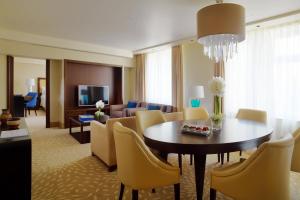 a dining room and living room with a table and chairs at Armenia Marriott Hotel Yerevan in Yerevan