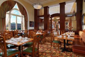 ein Restaurant mit Tischen und Stühlen und einem großen Fenster in der Unterkunft Armenia Marriott Hotel Yerevan in Yerevan