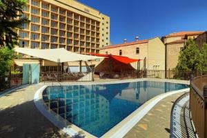 a swimming pool in front of a hotel at Armenia Marriott Hotel Yerevan in Yerevan