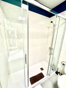 y baño con ducha y puerta de cristal. en Luxury Suite Sea Front III, en Playa Honda