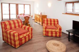 a living room with two chairs and a bed at Chalet La Primula in Santa Maria Maggiore