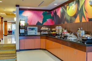 Fairfield Inn and Suites by Marriott Titusville Kennedy Space Center في تيتوسفيل: مطبخ مطعم مع كونتر عليه طعام