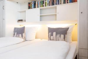 1 dormitorio con 2 camas y estanterías en Andreas-Dirks-Str-1-2-OG-Wohnung-207, en Westerland
