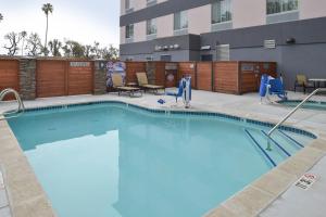 einen Pool in einem Hotel mit Stühlen und Tischen in der Unterkunft Fairfield Inn & Suites by Marriott Santa Cruz in Santa Cruz