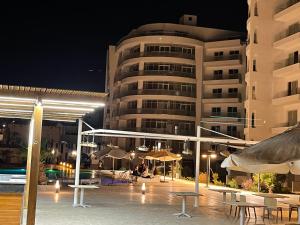 un edificio con mesas y sombrillas por la noche en شقة بمنتجع علي البحر en Hurghada