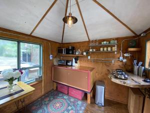 eine Küche mit einer Theke und einem Tisch in einem Zimmer in der Unterkunft Boho Bungalow in Nelson