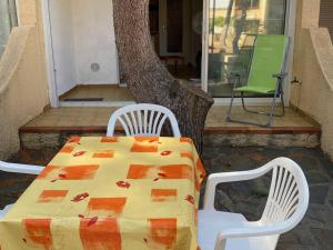stół i dwa krzesła na ganku z drzewem w obiekcie Studio Cabine 4 Pers, Terrasse, Parking Privé, Proche Plage et Commerces, La Franqui - FR-1-81-585 w mieście Leucate +3 zdjęcia