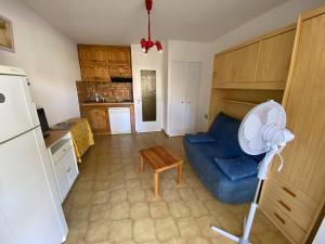 kuchnia z niebieską kanapą i lodówką w obiekcie Studio Cabine 4 Pers, Terrasse, Parking Privé, Proche Plage et Commerces, La Franqui - FR-1-81-585 w mieście Leucate