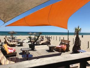 plaża z leżakami i parasolami oraz ocean w obiekcie Studio Cabine 4 Pers, Terrasse, Parking Privé, Proche Plage et Commerces, La Franqui - FR-1-81-585 w mieście Leucate