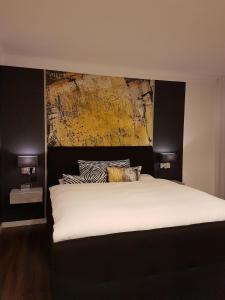 1 dormitorio con 1 cama grande y una pintura en la pared en Ferienhaus für 2 Personen ca 100 qm in Ahorn-Hohenstadt, Franken Tauberfranken en Hohenstadt