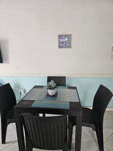 a dining room table with chairs and a sign on the wall at Memories by the Shore in Negril