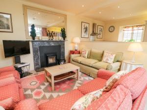 a living room with two couches and a fireplace at The Garden Rooms Lawkland in Austwick