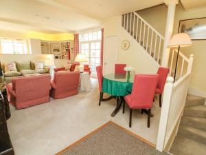 a living room with a table and red chairs at The Garden Rooms Lawkland in Austwick