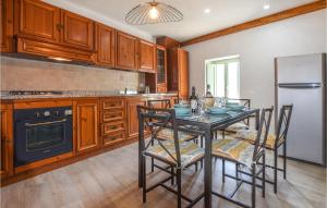 uma cozinha com uma mesa com cadeiras e um frigorífico em C Tonino em Pugliano