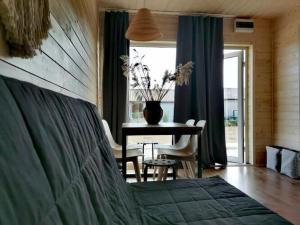 1 dormitorio con mesa, mesa y comedor en Cozy cottages in a family holiday resort, Jezierzany, en Jezierzany