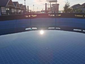 um reflexo do sol numa piscina em Cozy cottages in a family holiday resort, Jezierzany em Jezierzany