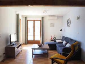 a living room with a blue couch and a tv at Holiday home with private pool, Vaison-la-Romaine in Vaison-la-Romaine