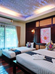 a bedroom with three beds with a star ceiling at Nan Bluesky Resort and Spa in Nan