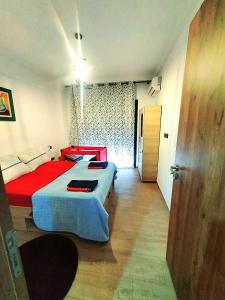 a bedroom with a red and blue bed and a door at Bonheur Partagé 2chambres in Marrakech