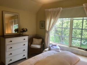 um quarto com uma cama, uma cómoda e uma janela em Hawk's Nest Bed & Breakfast em Bathurst