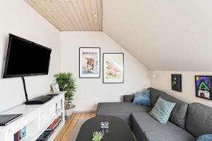 a living room with a couch and a flat screen tv at Brddegade 14, 3760 Gudhjem in Gudhjem