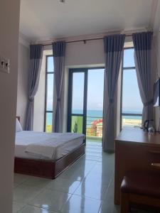 een slaapkamer met een bed en uitzicht op de oceaan bij Binh Minh Hotel in Quy Nhon