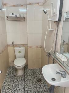 een badkamer met een toilet en een wastafel bij Binh Minh Hotel in Quy Nhon