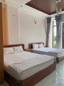 een slaapkamer met 2 bedden en een raam bij Binh Minh Hotel in Quy Nhon