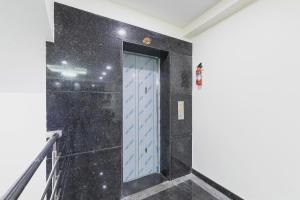 a hallway with a blue door in a wall at Capital O Regal suites in Bengaluru +69 photos