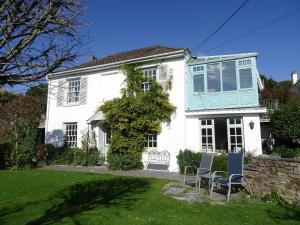 een wit huis met twee stoelen in de tuin bij Mount Pleasant in Padstow