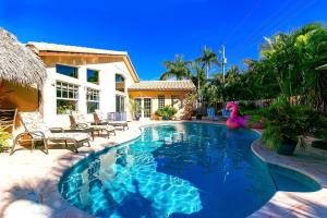 uma piscina com um flamingo rosa num quintal em LUX 4 Bedrooms Private HTD Salt Water Pool With Concierge Service em Deerfield Beach