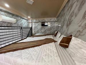two beds in a room with marble walls at Centralhome 2 in Plei Brêng