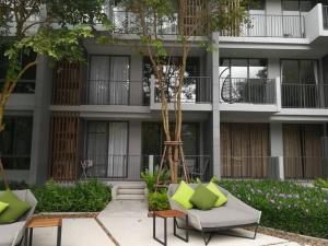 an apartment building with green pillows in the courtyard at The Valley byJT in Ban Huai Sok Noi