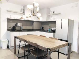 a kitchen with a wooden table and a refrigerator at The Valley byJT in Ban Huai Sok Noi