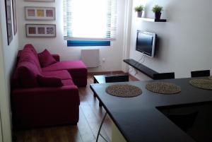 a living room with a purple couch and a table at Apartamentos Reservas León in San Isidro