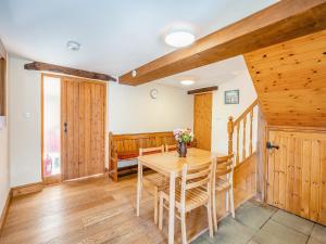comedor con mesa de madera y sillas en Billy Croft Cottage, en Knock