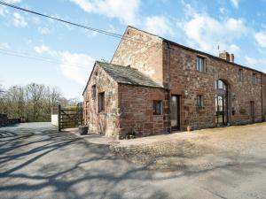 an old brick building sitting on the side of a road at Billy Croft Cottage in Knock